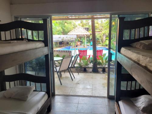 a room with bunk beds and a patio with a pool at Hostal Hilltop Palomino in Palomino