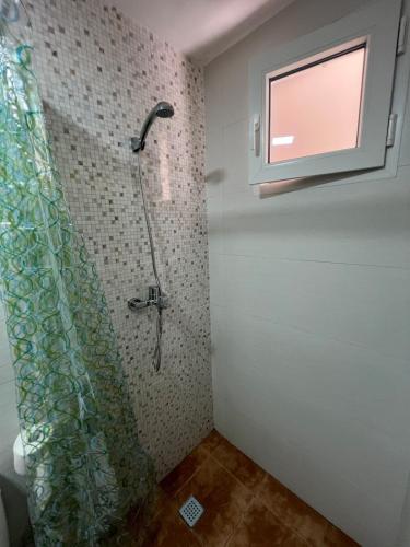 a bathroom with a shower with a window and a television at Casa Darío in Ceuta