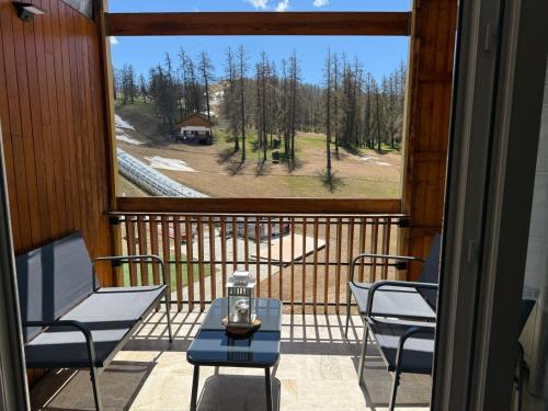 a balcony with chairs and a table and a window at Christiana studios en hyper centre de Valberg aux pieds des pistes in Valberg