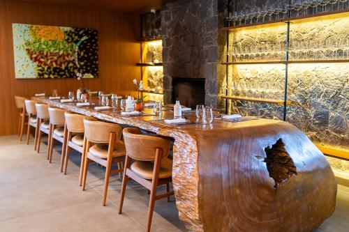 a large wooden table in a restaurant with a long bar at NÖR Hotel & SPA in São Roque