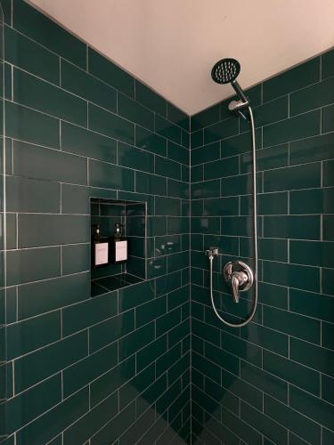 a green tiled bathroom with a shower at carpe diem sistina in Rome