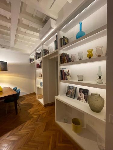 a room with white shelves with vases and a table at carpe diem sistina in Rome