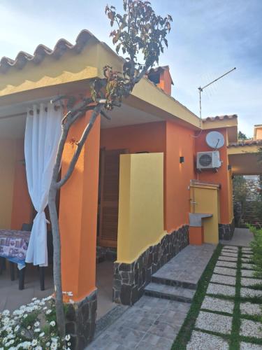 una casa con una casa naranja y amarilla en Villetta Chiara, en Costa Rei