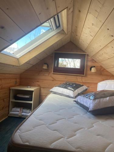 une chambre avec un grand lit dans un grenier dans l'établissement Tiny House Périgord Vert, à Coulaures