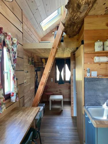 - une cuisine avec des murs en bois et un escalier dans une cabine dans l'établissement Tiny House Périgord Vert, à Coulaures