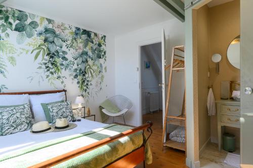sypialnia z łóżkiem i ścianą w kwiaty w obiekcie Les 13 lavoirs d'antan - chambre douceur de vivre w mieście Saint-Pierre-Église