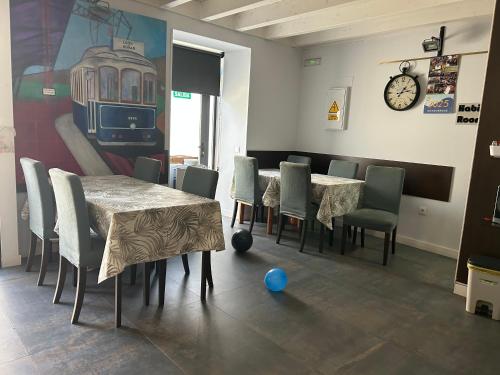 a dining room with a table and chairs and a clock at EL Hotelito in Alija del Infantado