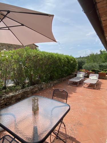 a table and chairs with an umbrella on a patio at Tenuta Lupinari in Bucine