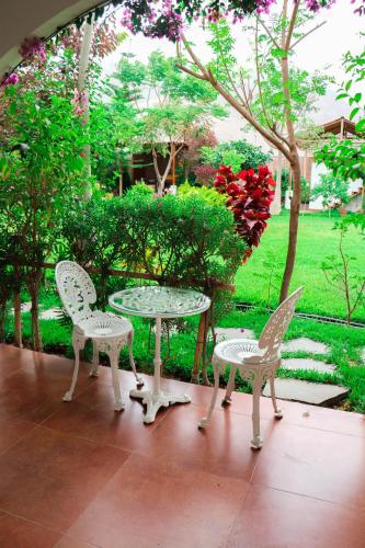 a patio with a table and two chairs and a table at Casa Hotel Mamaluna in Lunahuaná