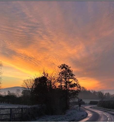 a road with a sunset in the sky at Apartment above Samantha Dadd Art Studio - in the Cotswolds in Tewkesbury