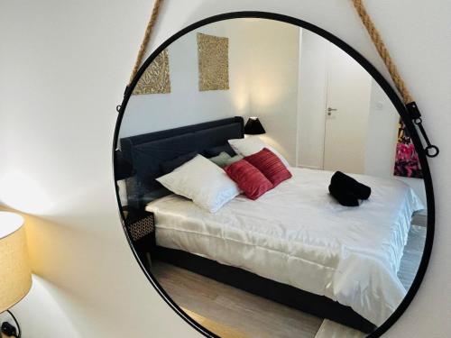 a mirror reflection of a bed in a room at Luneïa - romantic getaway, sauna and private spa in Chavanod