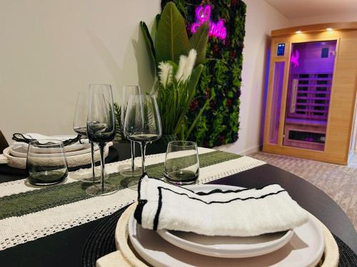 a table with wine glasses and plates on it at Luneïa - romantic getaway, sauna and private spa in Chavanod