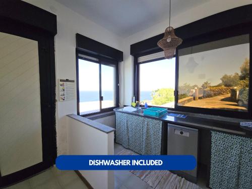a kitchen with a counter with a view of the ocean at Dammuso - Campobello - AFFITTICA in Pantelleria