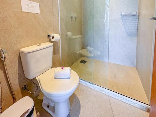 a bathroom with a toilet and a glass shower at Hotel Recanto do Atalaia in Arraial do Cabo