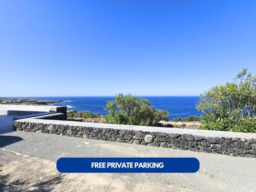 a stone retaining wall with the ocean in the background at Dammuso - Campobello - AFFITTICA in Pantelleria