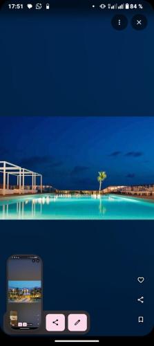 a cell phone sitting next to a picture of a pool at Hôtel Novotel in Kika