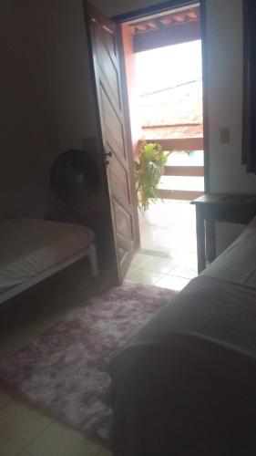 a bedroom with an open door with a plant in the window at Hospedaria meu Lar in Rio das Ostras