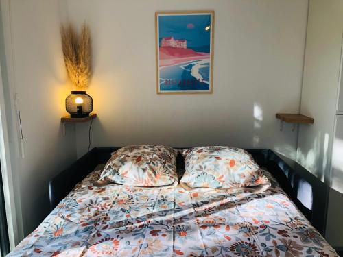 - un lit avec deux oreillers et une photo sur le mur dans l'établissement Studio, à Boucau