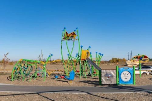 a playground in a parking lot with a green at Elegant & Cozy 2 Bdrm Basement suite near WEM in Edmonton
