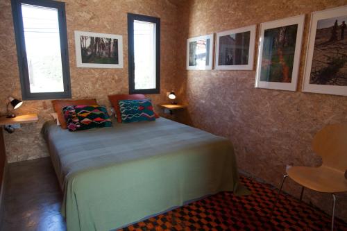 une chambre avec un lit dans une pièce avec des fenêtres dans l'établissement Maison colorée dans un jardin, à Gaillac