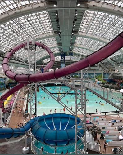 a large indoor swimming pool with a water slide at Elegant & Cozy 2 Bdrm Basement suite near WEM in Edmonton