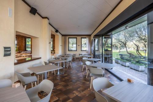 a restaurant with tables and chairs and windows at Hotel Ideal in Sirmione