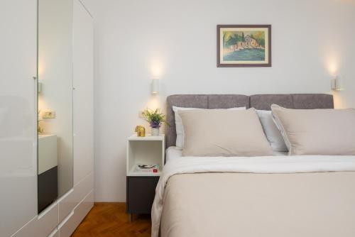 een slaapkamer met een groot bed met witte kussens bij Holiday Residence Maja in Katuni