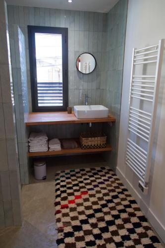 une salle de bain avec un lavabo et un miroir dans l'établissement Maison colorée dans un jardin, à Gaillac
