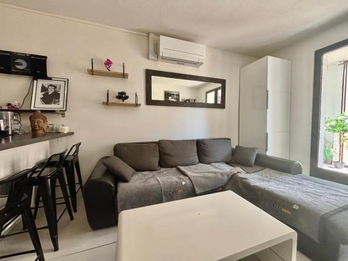 un salon avec un canapé et une table dans l'établissement Logement de plein pied tout confort, au Barcarès