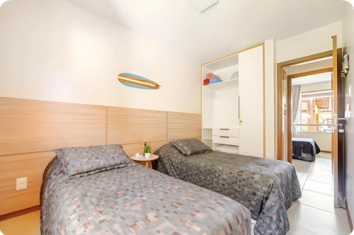 a bedroom with two beds and a mirror at Bioflora Itacimirim Novo village 44 in Camacari