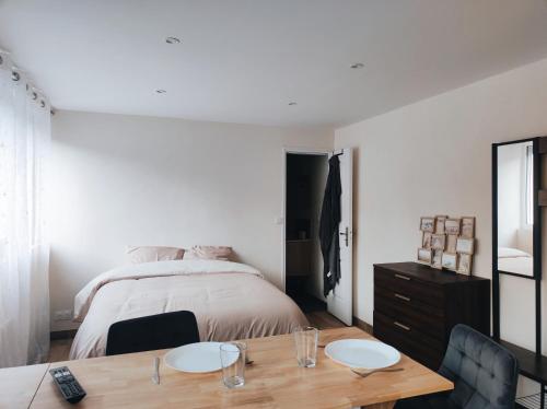 une chambre avec un lit, une table et des chaises dans l'établissement Studio Carentan, à Carentan