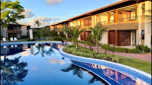 a swimming pool in front of a building at Bioflora Itacimirim Novo village 44 in Camacari