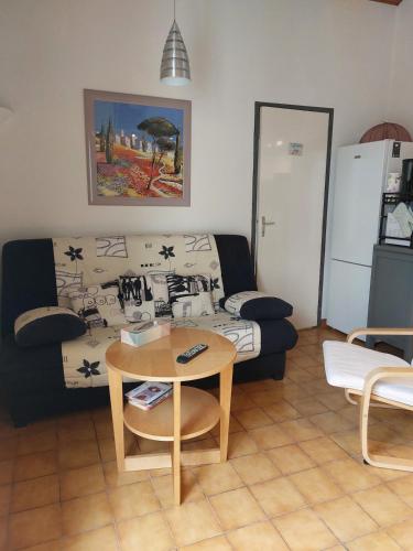un salon avec un canapé et une table dans l'établissement Maison dans résidence avec piscine, à Saint-Palais-sur-Mer