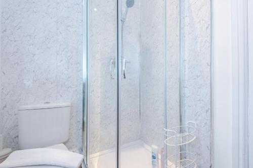 a bathroom with a glass shower with a toilet at Stylish 3 Bedroom Home with Driveway, Family and Business Friendly in Mold