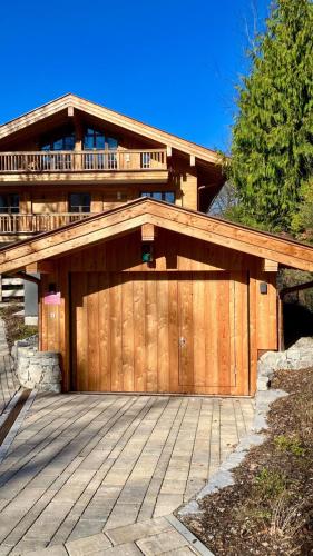 a house with a wooden garage with a deck at Leos Wallbergblick in Rottach-Egern