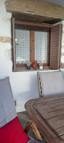 a table and chairs in a room with a window at Traditional house paros in Sarakíniko