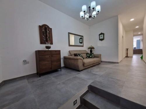 a living room with a couch and a chandelier at Azure in Għarb