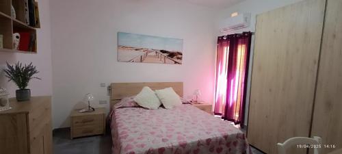 a bedroom with a bed with a pink bedspread at Azure in Għarb