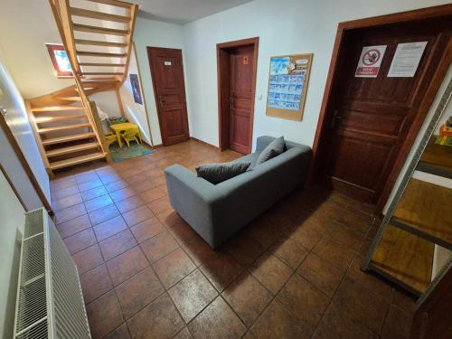 a living room with a couch and a staircase at Chalupa Jizerky U Juráška in Albrechtice v Jizerských horách