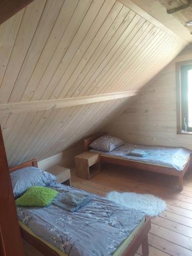 a attic room with two beds and a window at DOMEK NA GRANICY wynajem nocleg in Stankowa