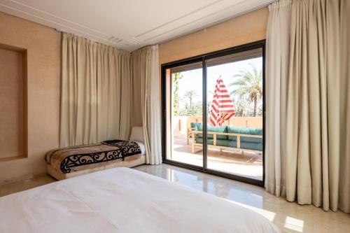 een slaapkamer met een bed en een grote glazen schuifdeur bij Villa les Palmiers in Marrakesh