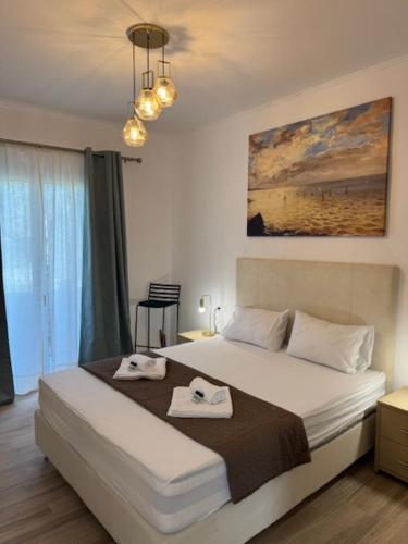 a bedroom with a large bed with two towels on it at Poseidon Garden View Apartment in Perivólion