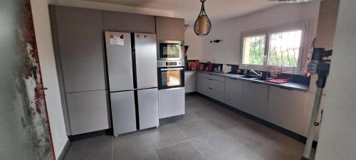 une cuisine avec des appareils électroménagers blancs et une fenêtre dans l'établissement Villa 100m2, à Hyères