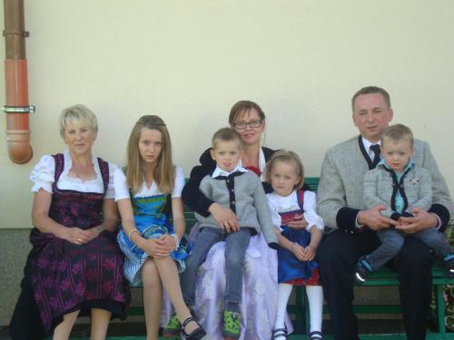 a family sitting on a bench posing for a picture at Gästehaus Schwoagerhof in Fügen