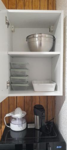 un placard avec quelques bols et assiettes sur un comptoir dans l'établissement Residence Jules Ferry, Appartement 4, à Angoulême