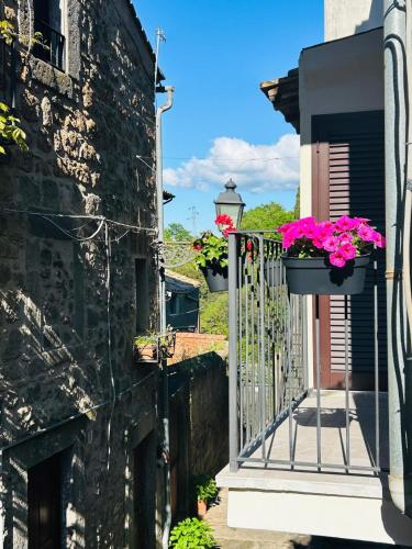a balcony with flowers on a stone building at WelcHome Vitorchiano in Vitorchiano