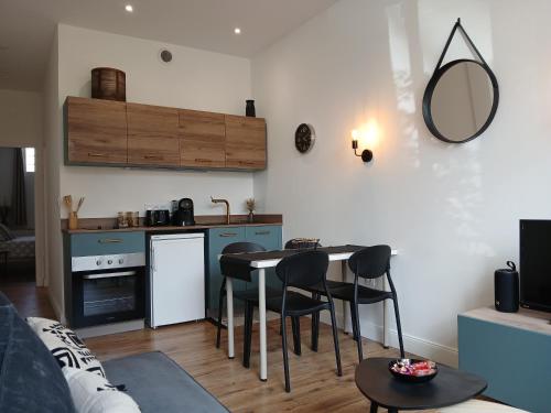 une cuisine et un salon avec une table et des chaises dans l'établissement Maison du Bonheur, gîte Les Tilleuls, à Le Pin