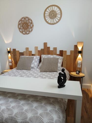 a bedroom with a large bed with a wooden headboard at Maison du Bonheur, gîte Les Tilleuls in Le Pin