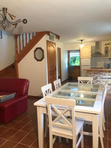 une cuisine et une salle à manger avec une table et des chaises dans l'établissement Maisonnette bretonne en campagne, à Locoal-Mendon