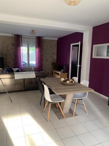 une salle à manger avec des murs violets, une table et des chaises dans l'établissement Chez vero, au Boulou